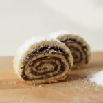 עוגיות מגולגלות תמרים מבצק פריך נימוח עם אבקת סוכר, מתכון למגולגלות תמרים פרווה שנמסות בפה לצד קפה, צילום תקריב מקצועי של עוגיות תמרים של פעם.